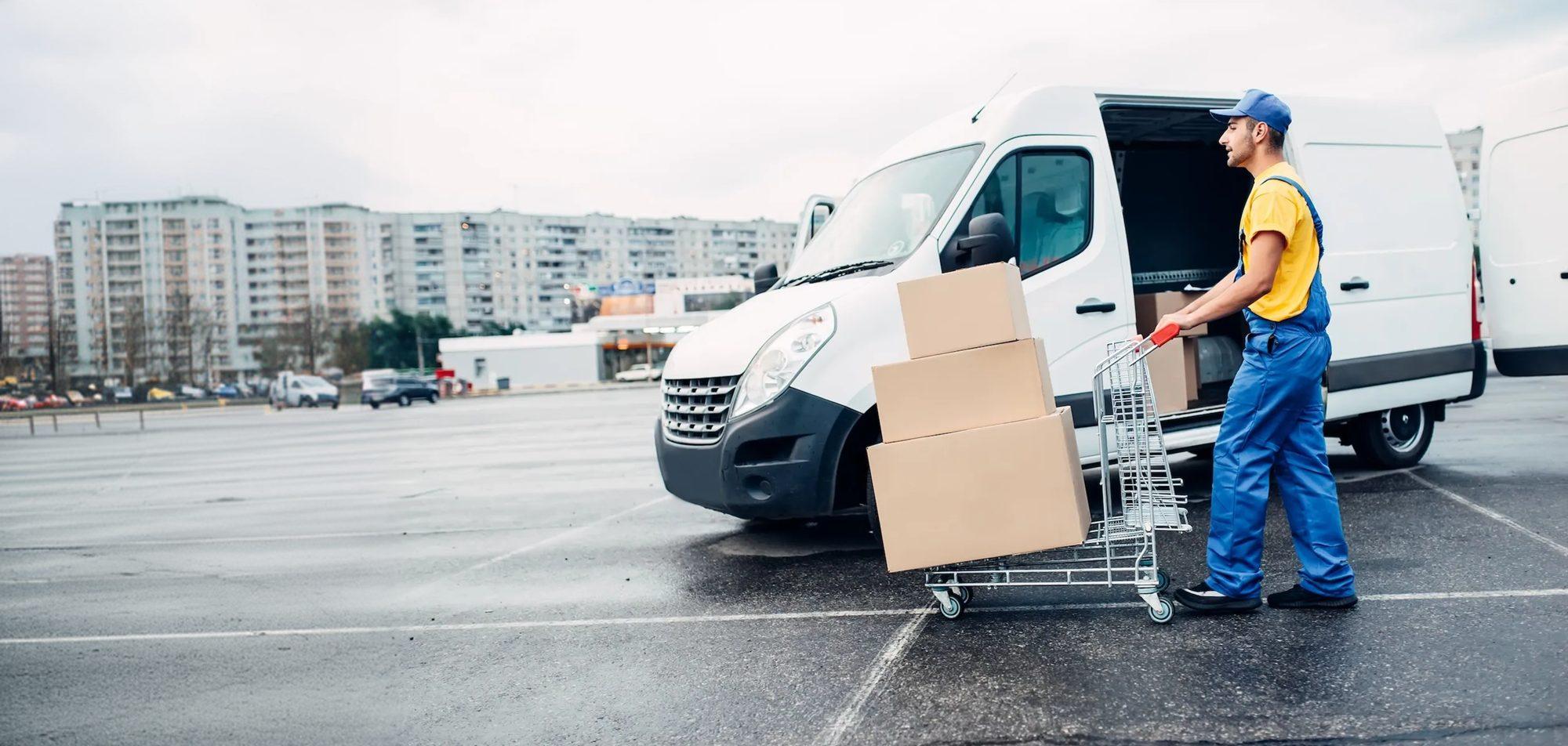 A delivery worker loading parcels beside a van.